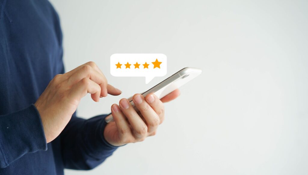 Close up of a man giving a five-star Google review to a local business on his mobile phone. 